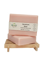 Two bars of Geranium Rose soap on a wooden stand with a white background