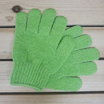 Green exfoliating glove on a wooden surface