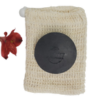 Activated Charcoal Handmade Natural Soap Bar on sisal soap saver next to flower