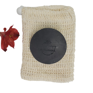 Activated Charcoal Handmade Natural Soap Bar on sisal soap saver next to flower