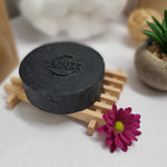 1 bar of Activated Charcoal Handmade Natural Soap Bar on wood soap dish next to flower