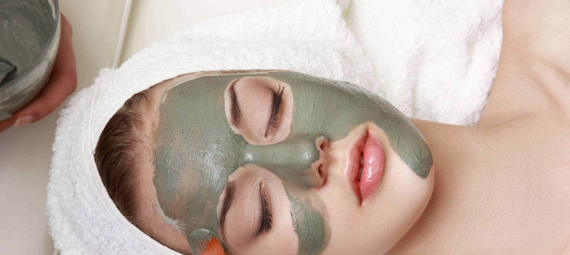 woman relaxing with green facial mask on face