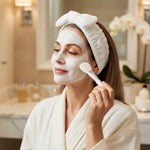Woman wearing the white spa headband while applying a face mask