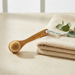 Bamboo facial brush with natural bristles and hanging ribbon