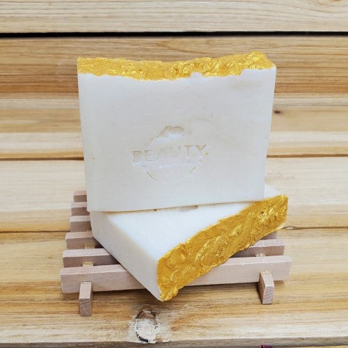 2 bars of gold coast soap on a wood soap dish