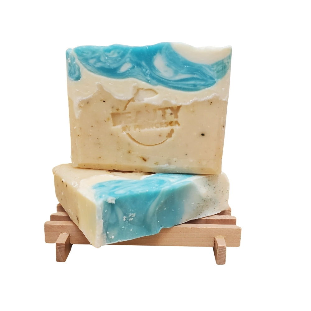 Two Coastal Spa handmade soap bars on a wooden soap dish