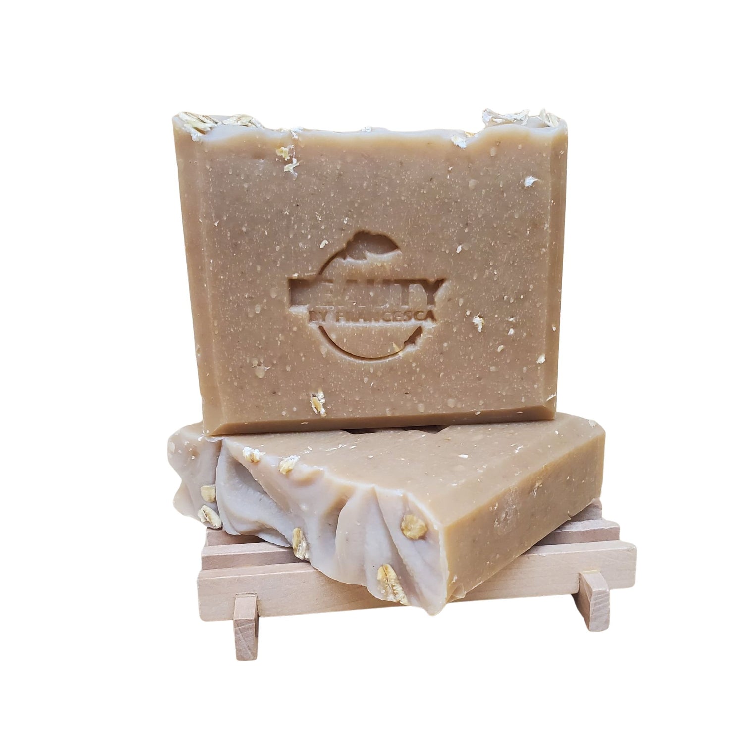 Two bars of honey oatmeal chai soap on a wooden stand with a white background
