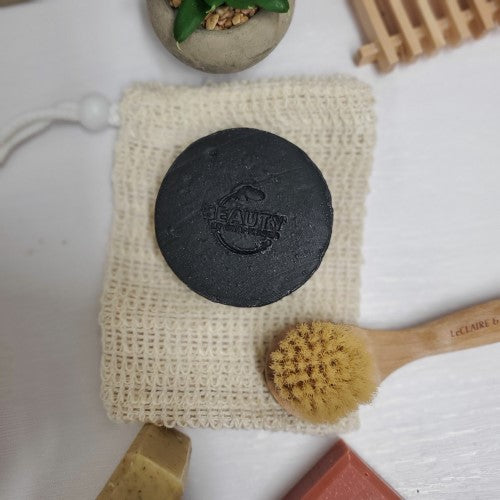 Activated Charcoal Soap  on a sisal next to a facial brush