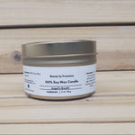 Angel's  Breath Candle in a gold tin with lid closed against a wood background
