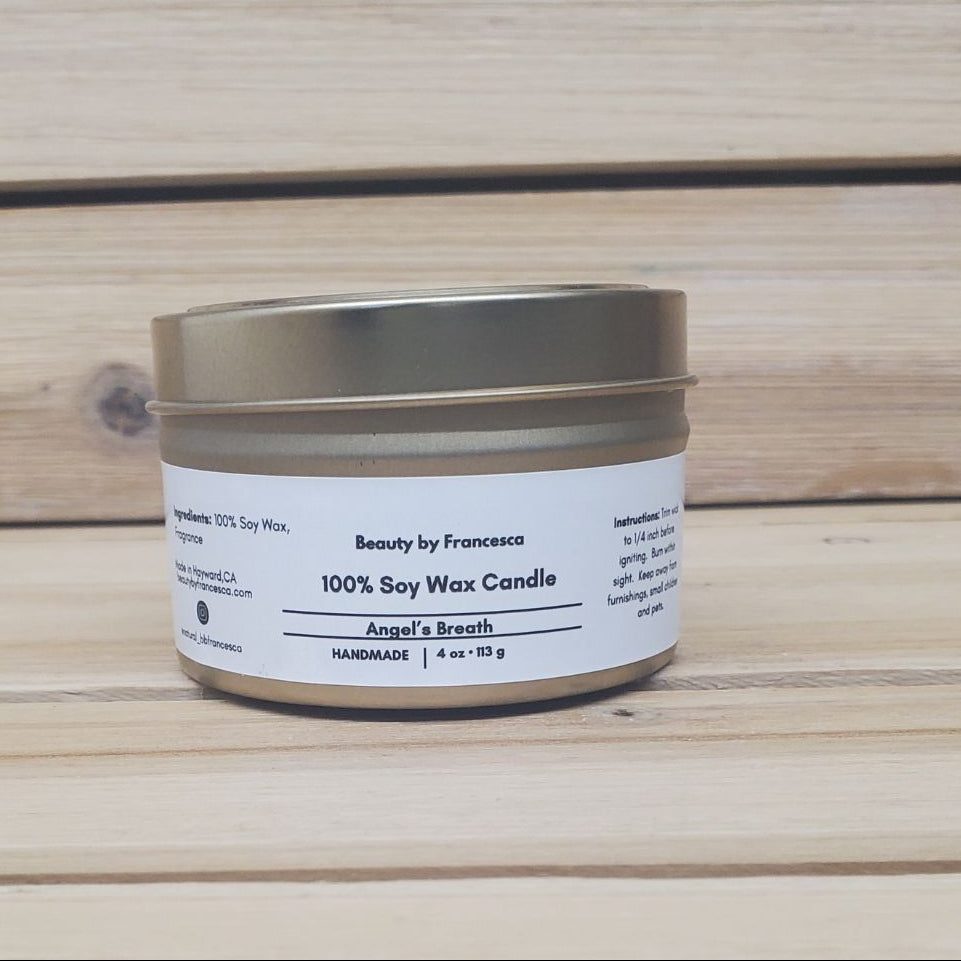 Angel's  Breath Candle in a gold tin with lid closed against a wood background