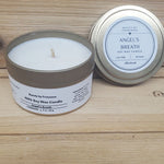 Angel's Breath Candle in a gold tin against a wood background