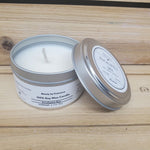 Eucalyptus Spa Candle in a silver tin with lid resting on side  against a wood background