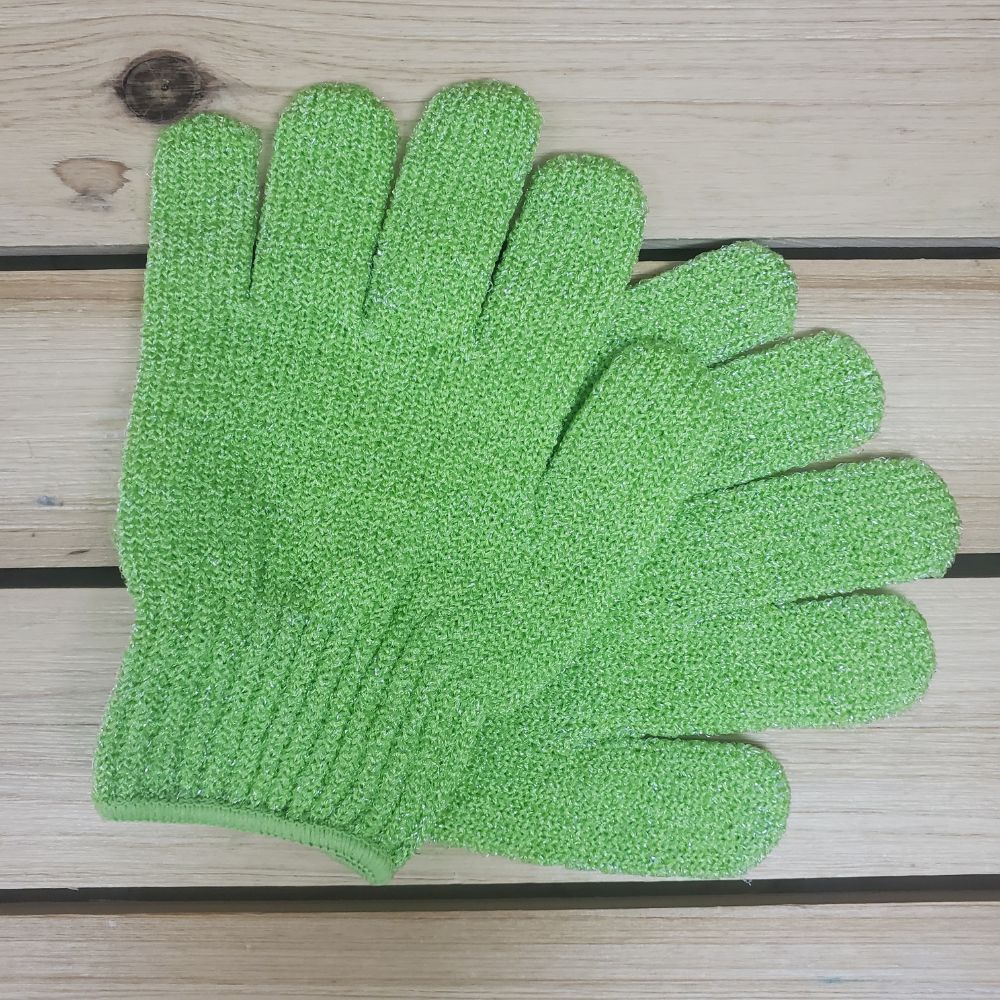 Green exfoliating glove on a wooden surface