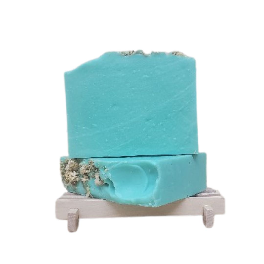 Green soap bar decorated with chamomile on top on a white background