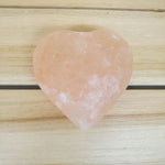 Heart Shaped Pink Himalayan salt Body Massage Stone on a wooden surface 