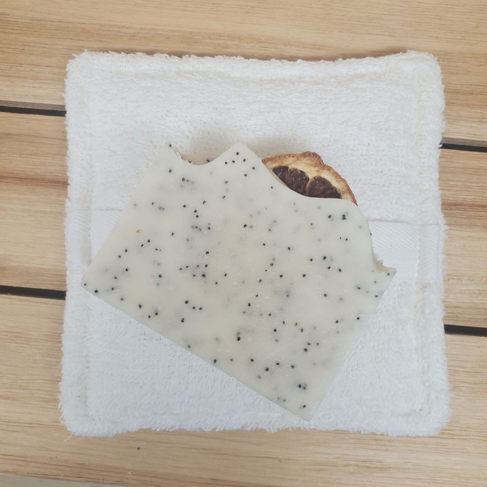 Soaping Sponge Pocket  with lemon poppy seed soap against a wood background