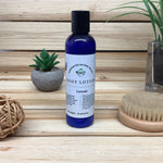 Lavender Body Lotion against wood background with small plants in background