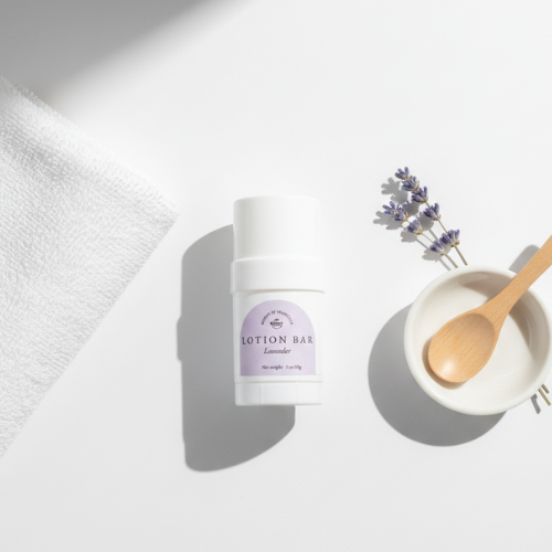 Mini Lavender Lotion Bar next to a towel and a sprig of lavender