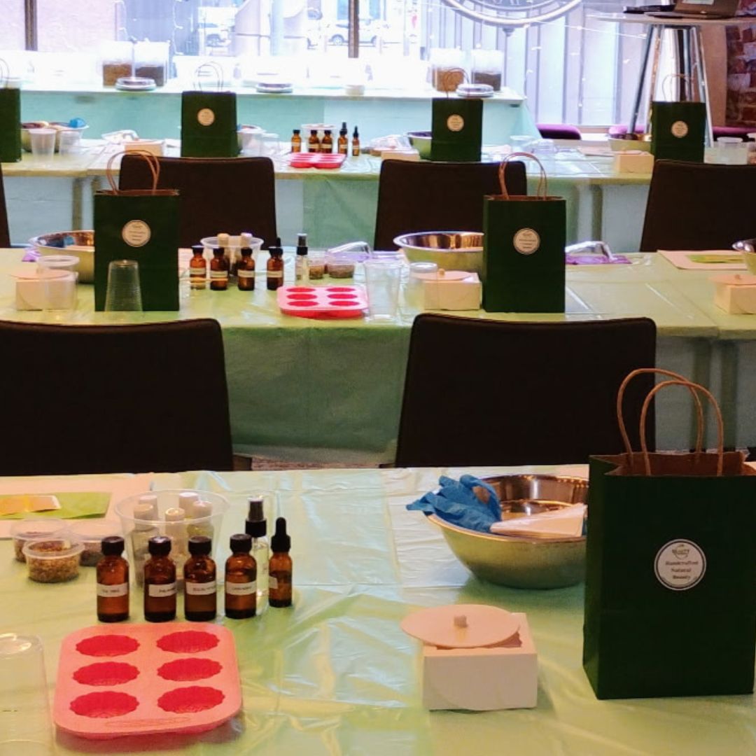 Tables with various items including bottles, a mold, and a bag in a room setting.