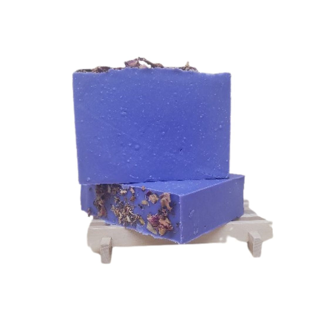 Two Purple Reign soap bars with roses on a wood soap dish against a white background