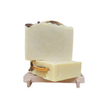 Two bars of soap on a wooden stand with a white background