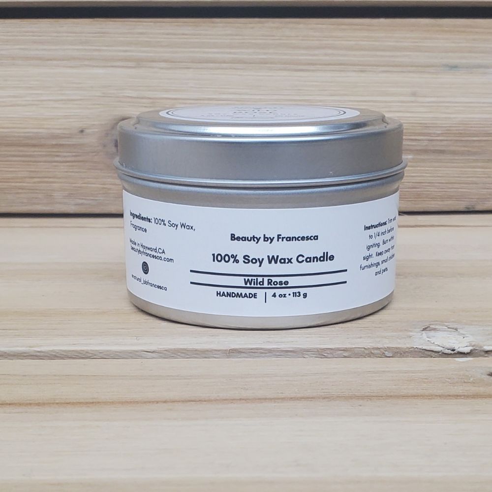 Wild Rose Soy Candle in a closed tin  on a wooden surface