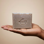 Bar of Beauty by Francesca honey oatmeal chai soap held in a hand against a beige background