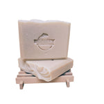 two bars of lavender orange soap on a soap dish white background
