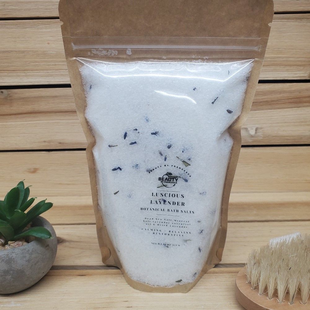 Luscious Lavender Bath Salts next to a  plant and a body brush