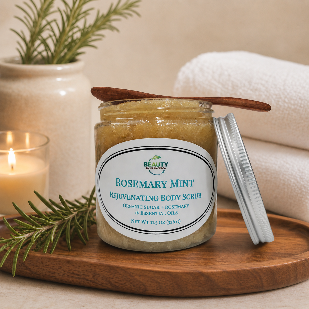 rosemary mint body scrub in spa setting with towels, candle and rosemary sprig