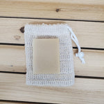 Bar of soap on a sisal soap saver against a wood background