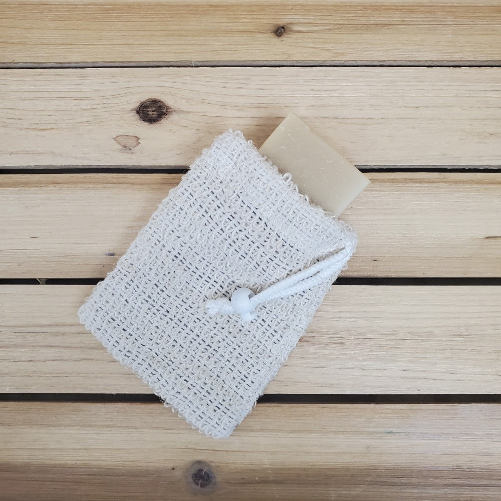 Sisal soap saver with a bar of soap in pouch on a wooden surface