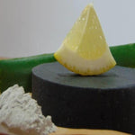 Lemon Wedge on top of Activated Charcoal Soap showing purity and freshness