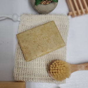 Chamomile Calendula Handmade Soap on reusable soap holder near tiny face brush