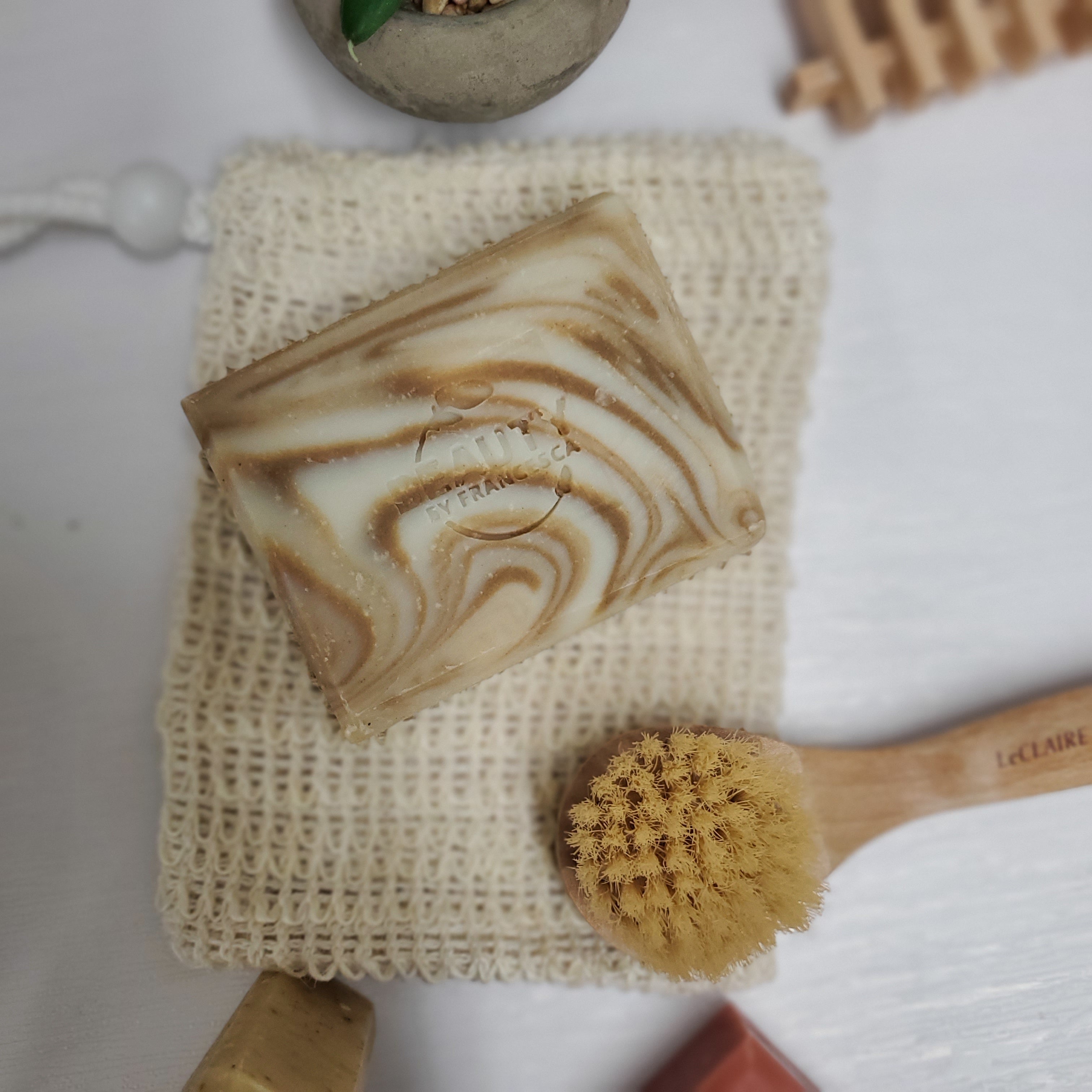Eucalyptus Orange Handmade Soap on reusable soap holder near tiny face brush