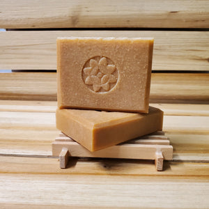 milk and honey soap bar front view 2 on soap dish wood background
